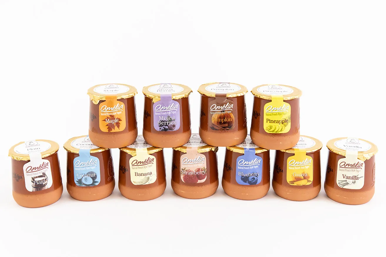 Why You Need OKC Commercial Photography - myheartcreative An assortment of 11 different flavors of Amelia Creamery French-style yogurt. Four of the yogurt jars are stacked on top of a row of seven jars on a white background.