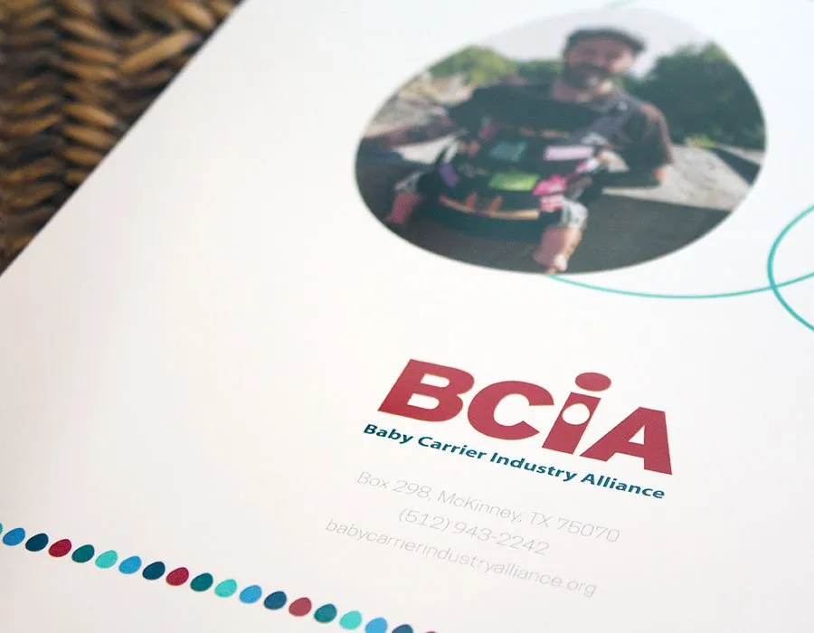 The BCIA logo, address, and phone number shown underneath a father carrying his baby in a baby carrier on the booklet's back cover. 