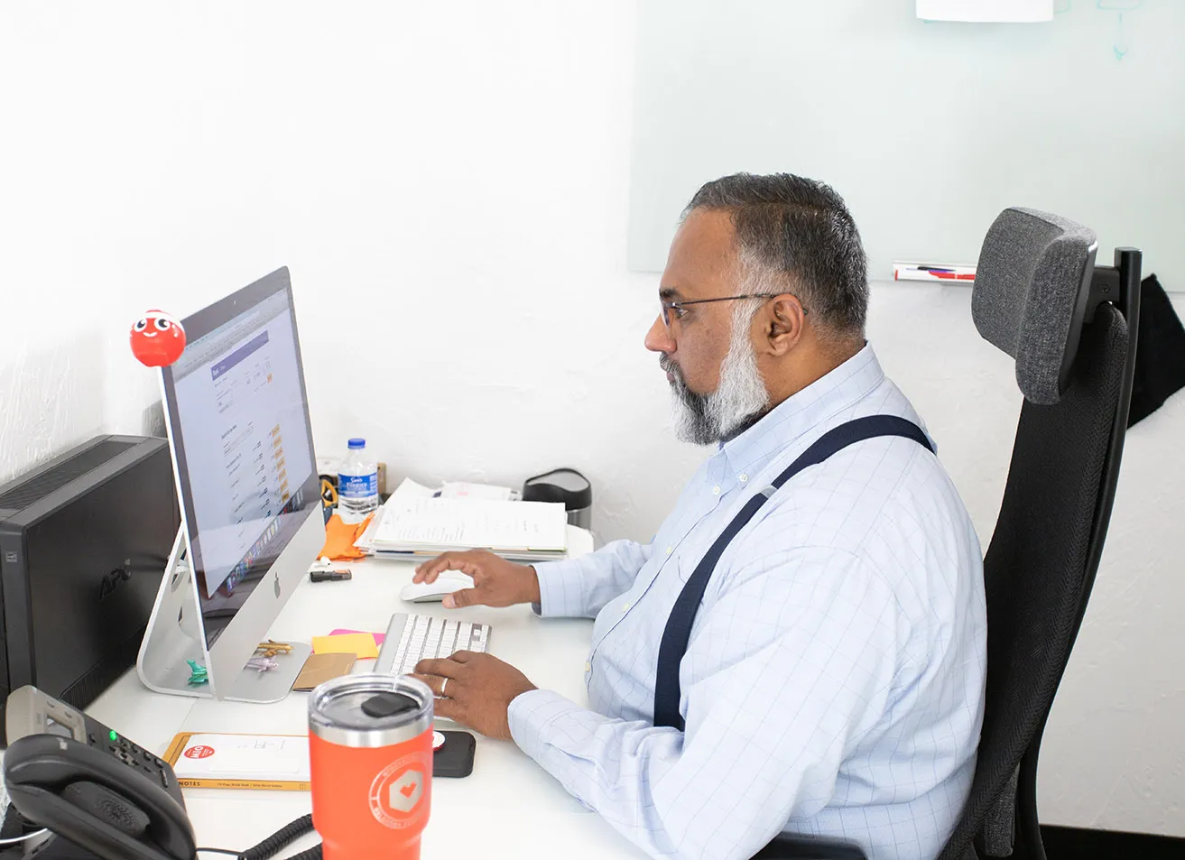 Sam, the Operations Director, sits at his desk and reviews analytics for a client's website. 