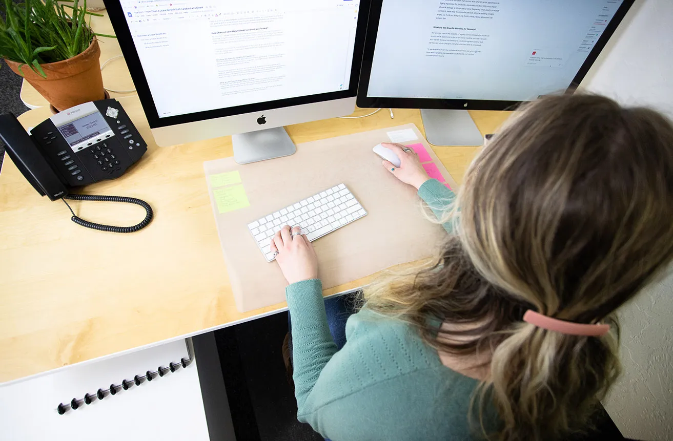 Kristen sits at her desk and writes content for a client's website. 
