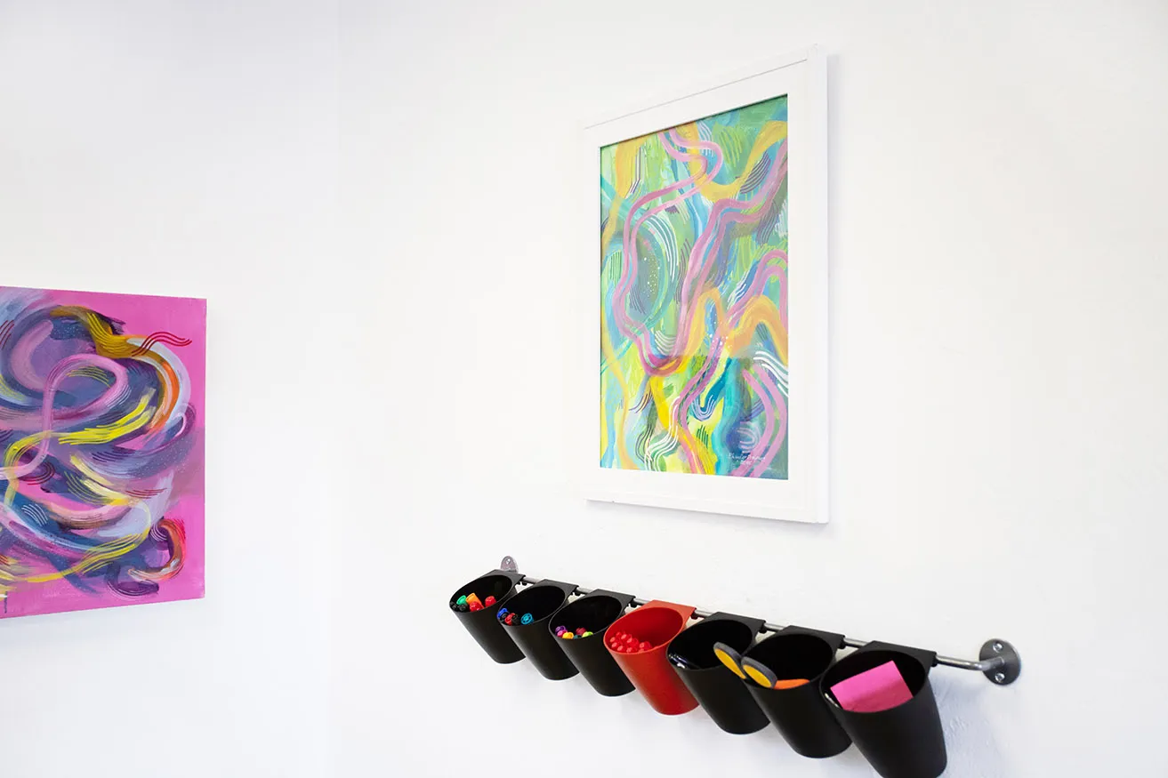 Two paintings by artist Chandler Domingos hang on the wall at an Oklahoma design company. 