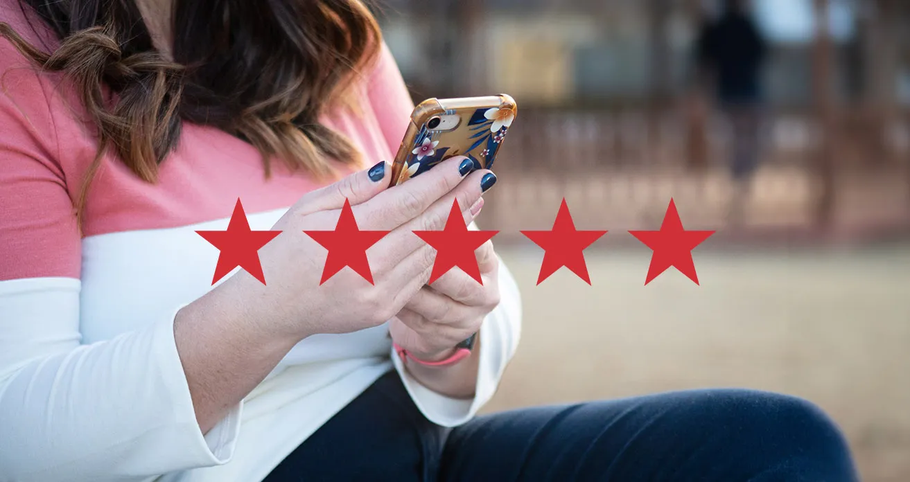 A myheartcreative client holding her smartphone. There are five red stars shown on the image. 