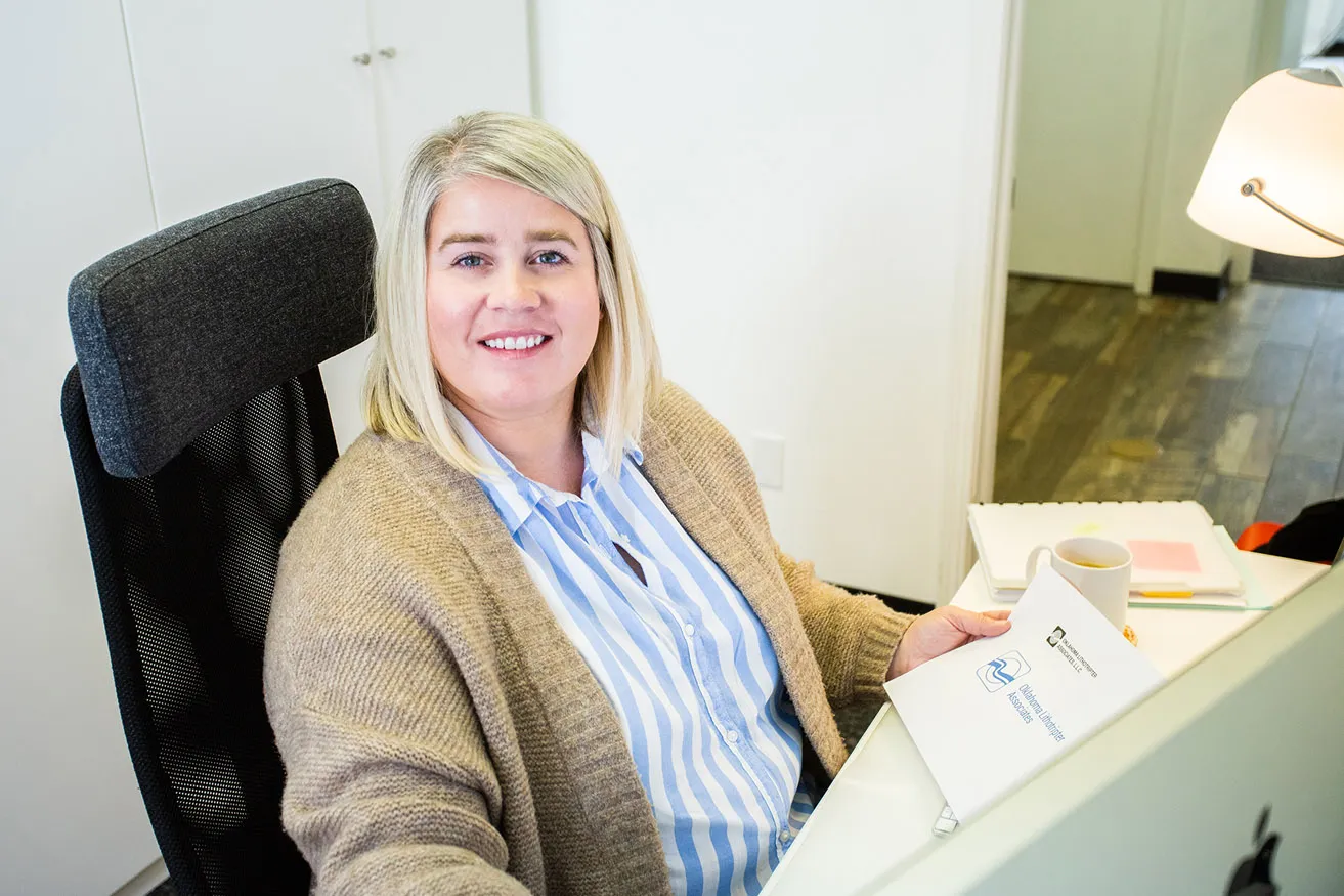 Amy, the Creative Director, reviews a logo design for the Oklahoma Lithotripter Associates at her desk in the studio. 