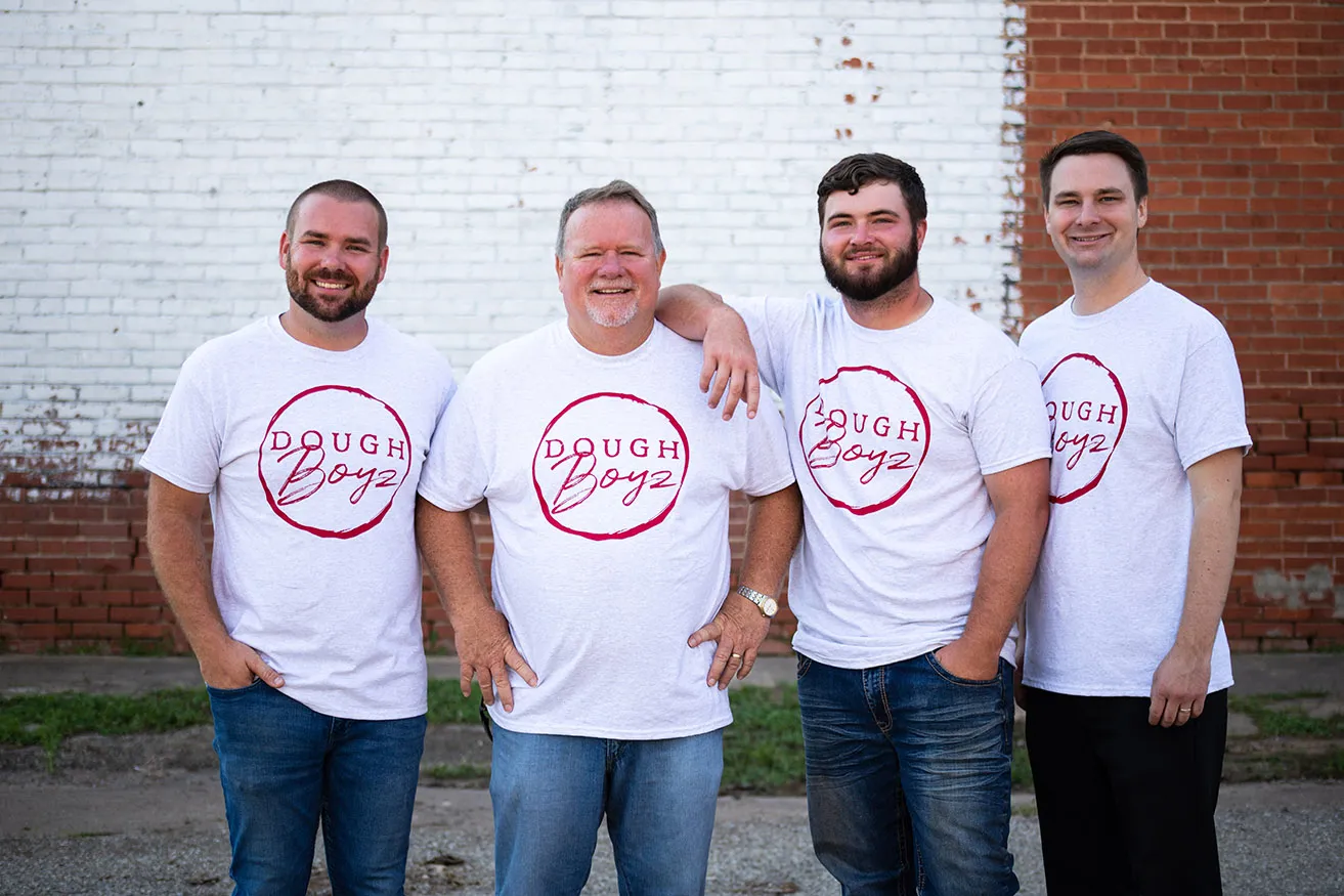 A professional photo of four members of the DoughBoyz team wearing branded t-shirts for their web OKC design. 