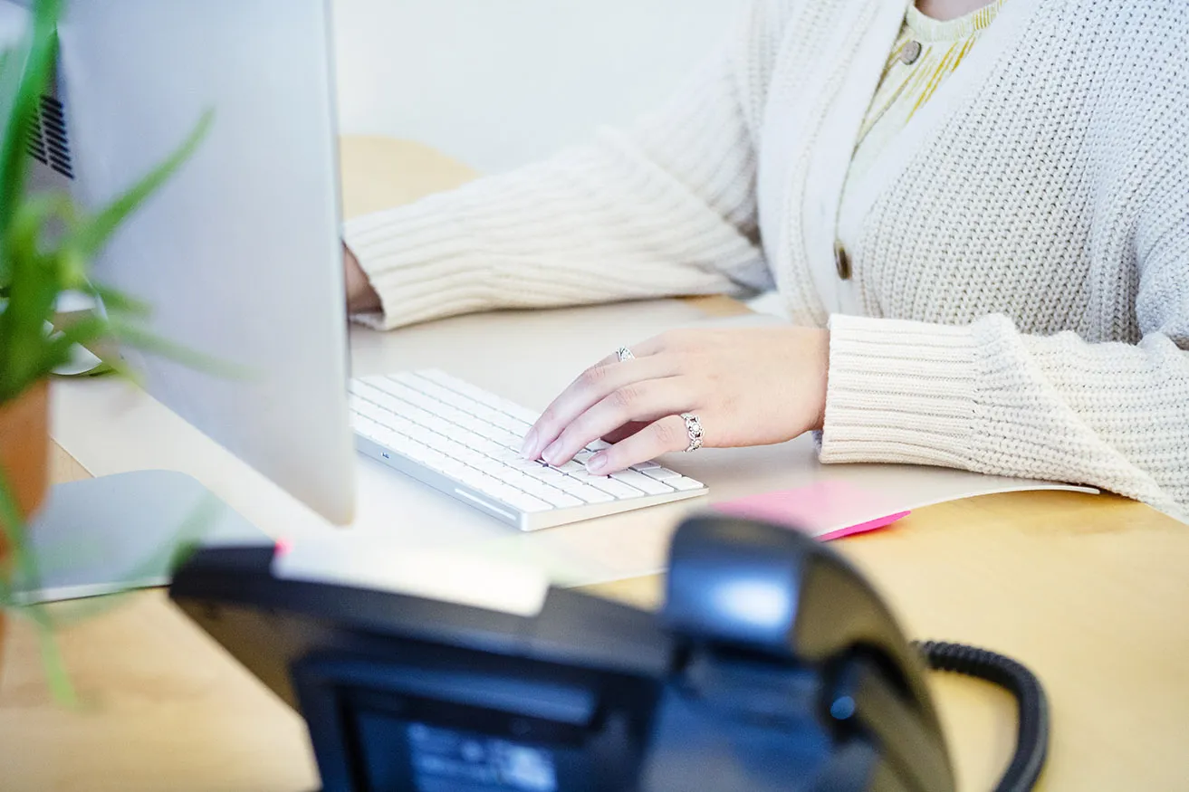 An Oklahoma marketing professional types social media content on her keyboard at the studio. 