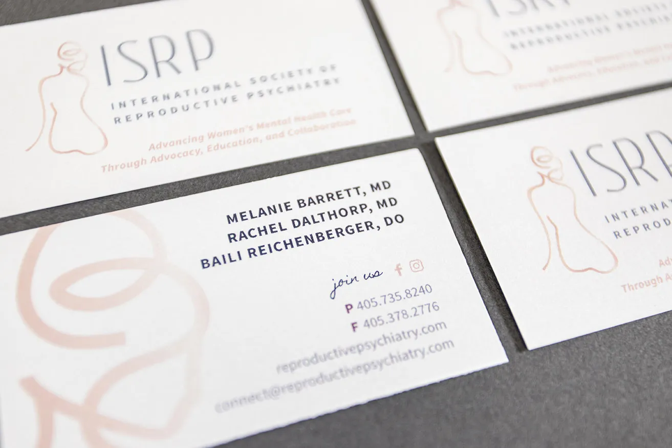 The front and back of the business card for the International Society of Reproductive Psychiatry (ISRP). Their logo showcases a beautiful pink gradient. 