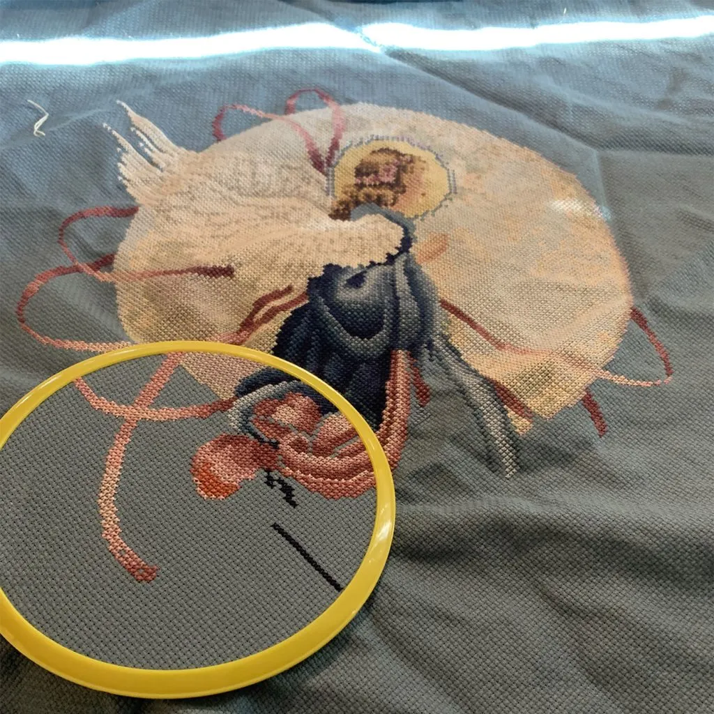 Creative New Things for Our Oklahoma Design Team - myheartcreative An cloth with an angel cross-stitched on it. Part of the cloth is secure under a cross-stitching hoop.