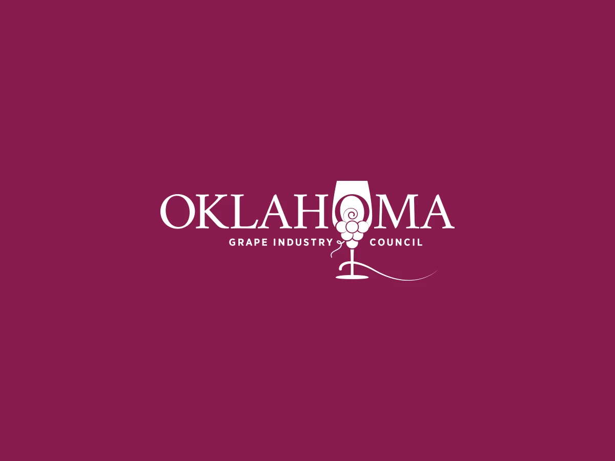 A mockup of the logo design OKC for the Oklahoma Grape Industry Council on a purple background. 