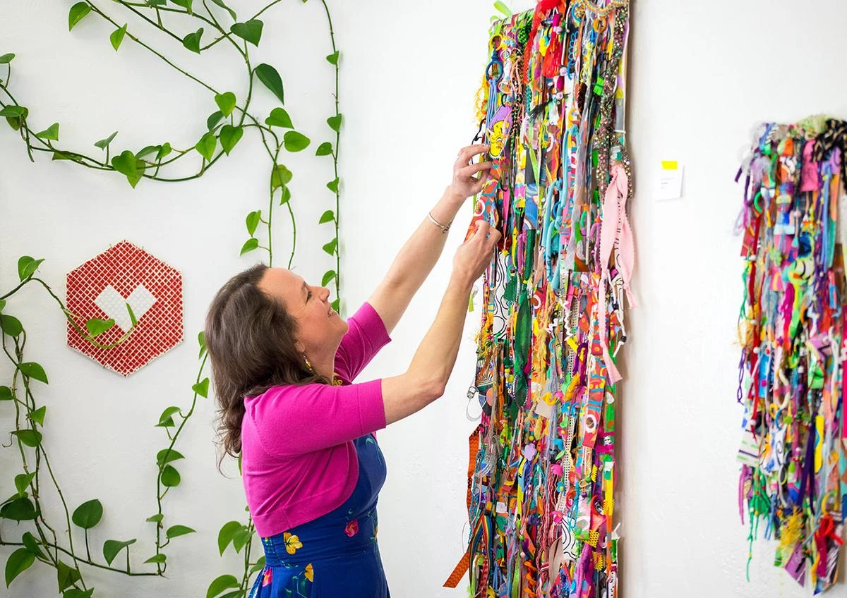 A Vision of Whimsy - myheartcreative Artist Bianca Roland adjusts the artistic elements on a large mixed media wall hanging at the myheartcreative studio.