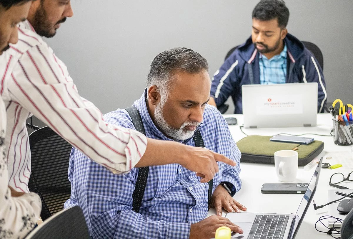 The Operations Director is shown SEO marketing Dallas analytics on a laptop by an SEO specialist. 