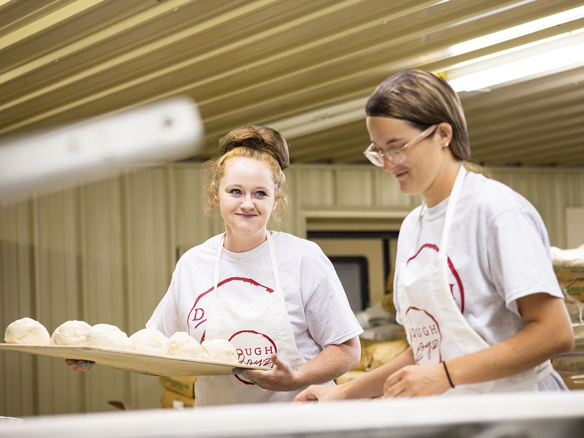 When to Use Dallas Commercial Photography vs. Stock - myheartcreative Two female pizza dough makers at the DoughBoyz location.