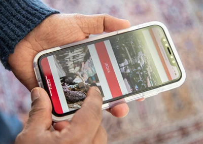 A man scrolling on the Power of a Nickel website on his smartphone.