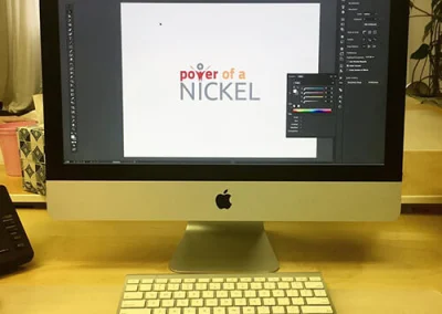 The Power of a Nickel logo being designed on a Mac desktop computer.