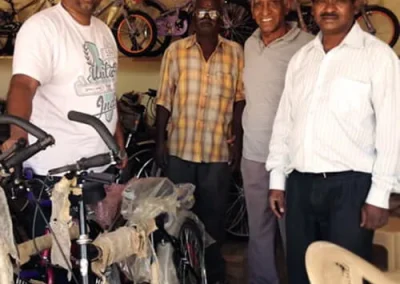 Operations Director, Sam, stands with three other men in a bike shop in India.