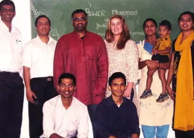 Sam and Amy smile with a group of individuals while doing mission work in India.