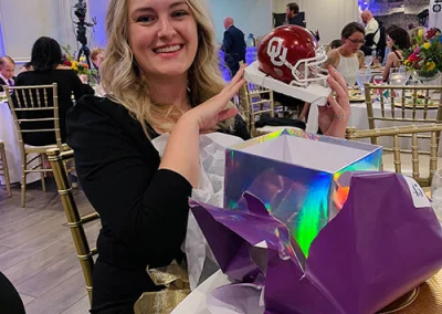 Project Coordinator, Kristen, opening a door prize at an event hosted by The Mack Impact.