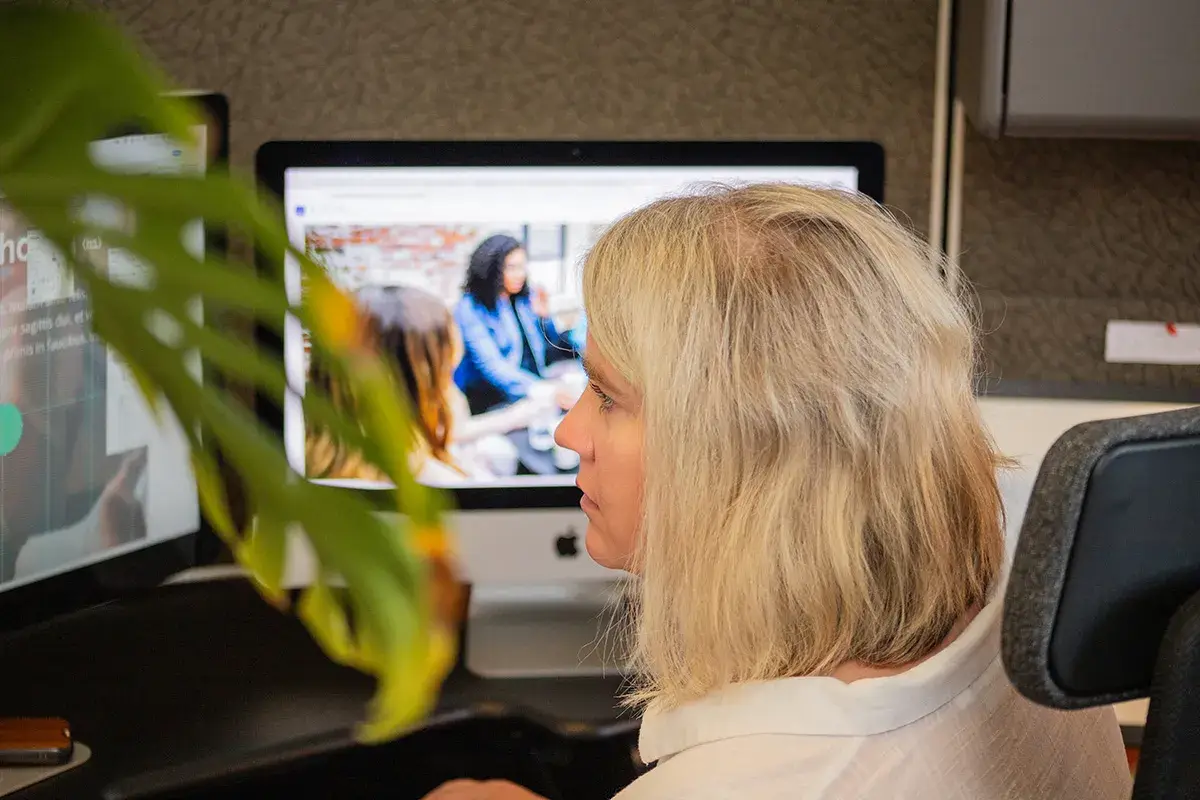 Amy looks at her computer while sitting at her desk