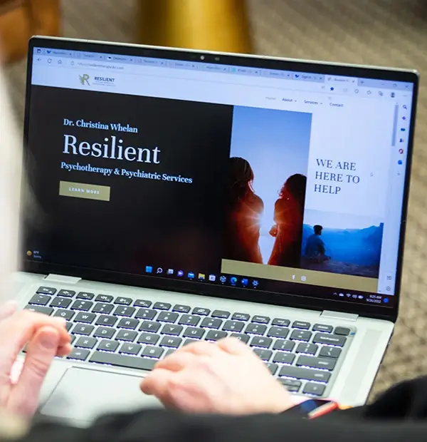 Someone looking at Resilient Psychotherapy's website on a laptop