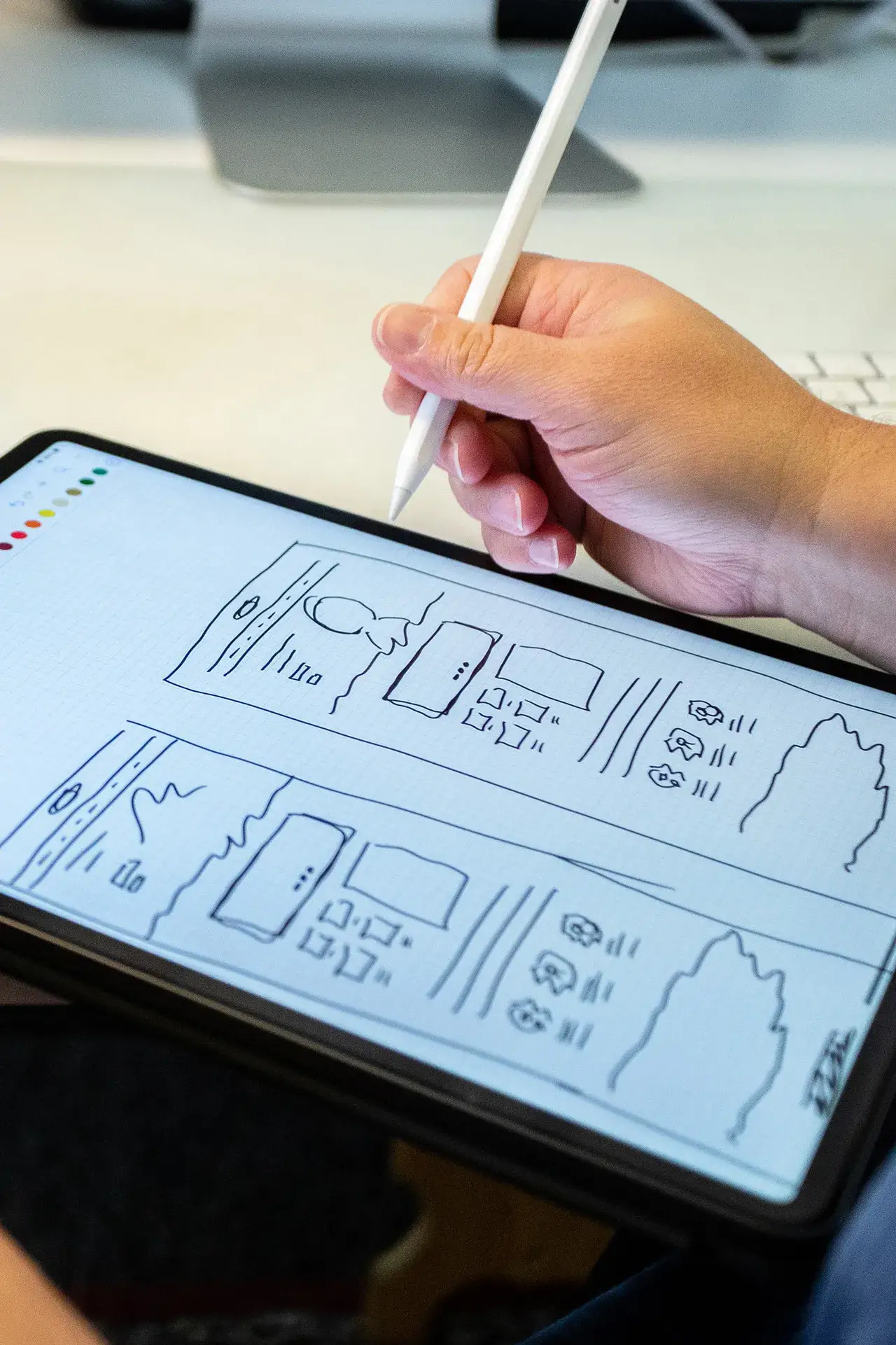 A designer taking notes on a website layout on an iPad