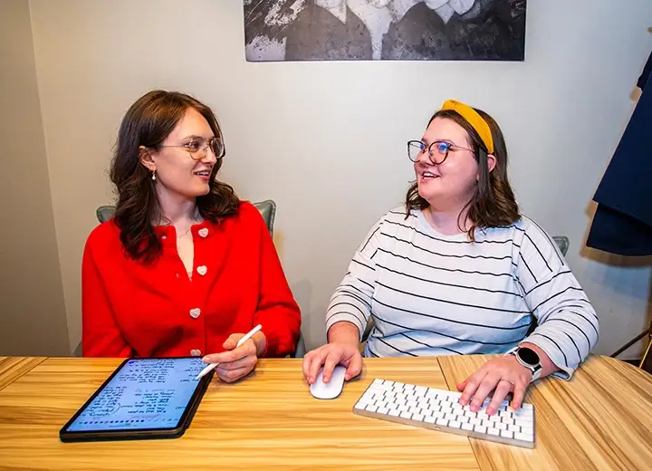 Kristen and Caitlin discussing project in conference room