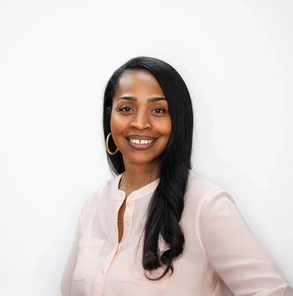 Woman smiling in front of white backdrop